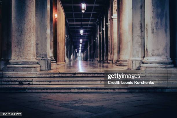 colonnade gallery at san marco square in venice, italy, illuminated at night - venice italy night stock pictures, royalty-free photos & images