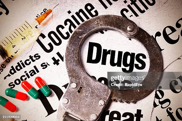 worn handcuff rests on headlines about drugs, pills &amp; syringe - cocaine stock pictures, royalty-free photos & images