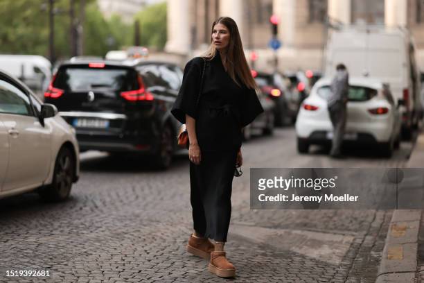 Veronika Heilbrunner seen wearing black kimono shaped jacket, black silk long skirt, gold choker necklace and earrings, colorful varnished leather...