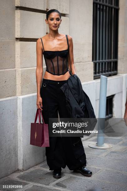 Guest wears a black sheer corset, black cargo pants, black mules, outside Zuhair Murad, during the Haute Couture Fall/Winter 2023/2024 as part of...