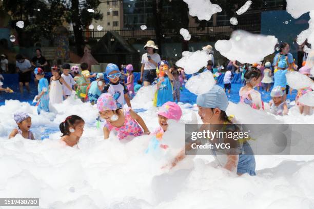 Children play with bubbles to cool off at a kindergarten on July 6, 2023 in Rongjiang County, Qiandongnan Miao and Dong Autonomous Prefecture,...
