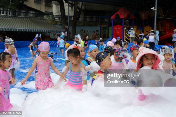 Children play with bubbles to cool off at a kindergarten on July 6, 2023 in Rongjiang County, Qiandongnan Miao and Dong Autonomous Prefecture,...