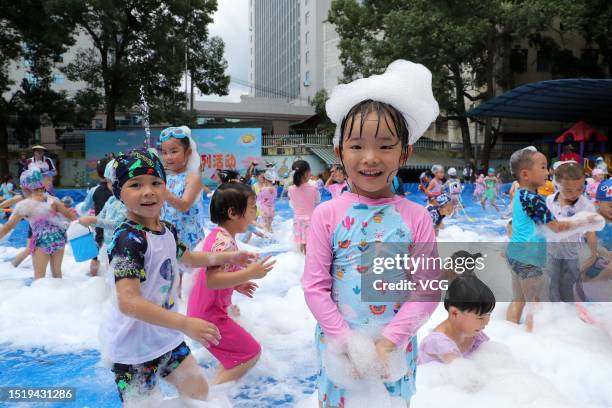 Children play with bubbles to cool off at a kindergarten on July 6, 2023 in Rongjiang County, Qiandongnan Miao and Dong Autonomous Prefecture,...