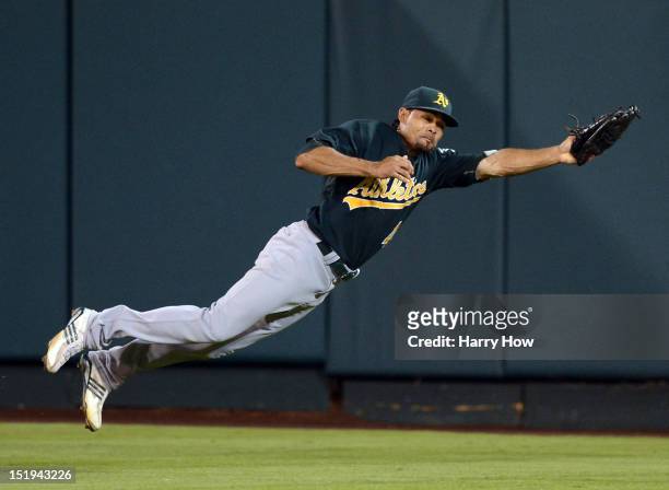 Coco Crisp of the Oakland Athletics makes a diving catch for an out of Chris Iannetta of the Los Angeles Angels during the fifth inning at Angel...