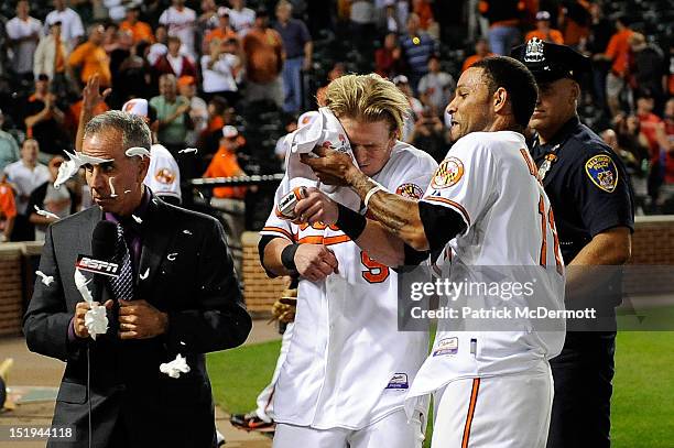 Baseball analyst Tim Kurkjian gets hit with the majority of the shaving cream pie that Robert Andino meant for Nate McLouth of the Baltimore Orioles...