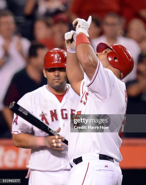 Albert Pujols of the Los Angeles Angels celebrates in front of Kendrys Morales after his homerun to become the first player to hit at least 30...