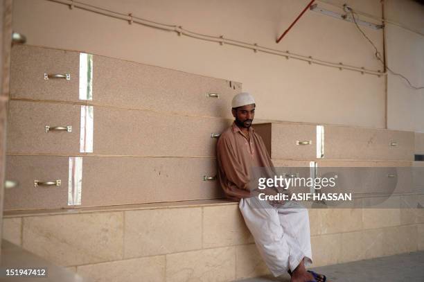Pakistani man mourns as he waits in the EDHI Morgue to identify his relative who was killed in a garment factory fire in Karachi on September 13,...