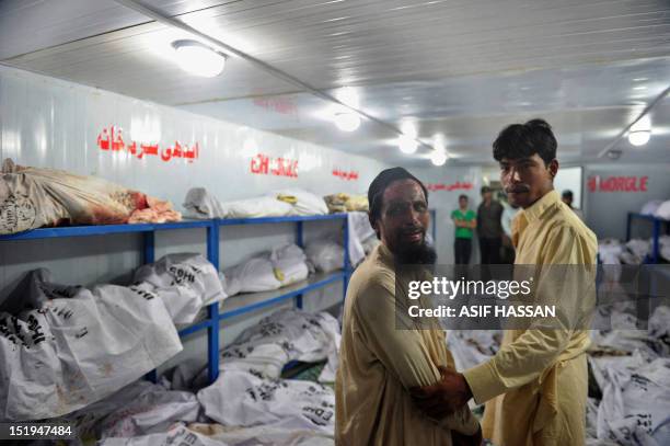 Pakistani man mourns as he stands in the EDHI Morgue to identify his relatives who were killed in a garment factory fire in Karachi on September 13,...