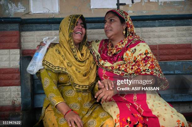 Pakistani women grieve as they wait at the EDHI Morgue to identify their relatives who died in a garment factory fire in Karachi on September 13,...