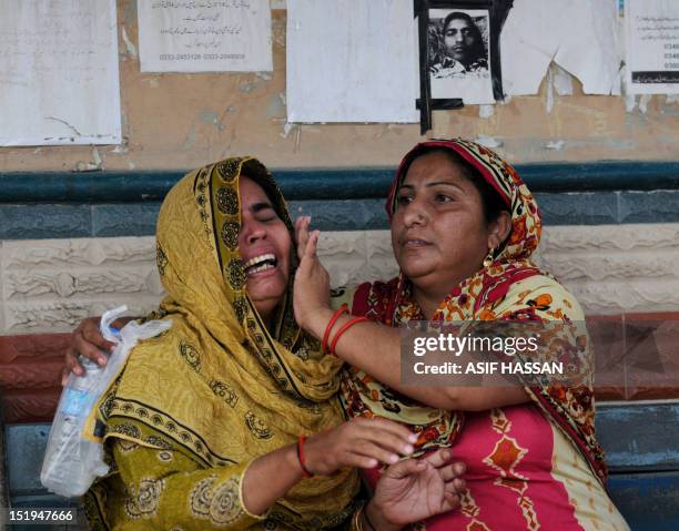 Pakistani women grieve as they wait at the EDHI Morgue to identify their relatives who died in a garment factory fire in Karachi on September 13,...