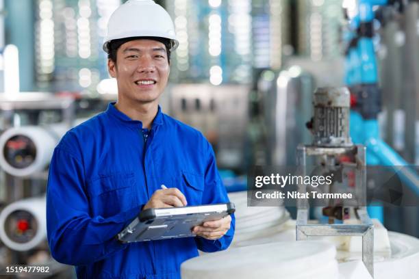 water pumping station monitoring system in the food processing industry. a male japanese service engineer in the water pumping control room to check performance and reliability of the pumping station via a tablet computer. - measuring potential business stock pictures, royalty-free photos & images