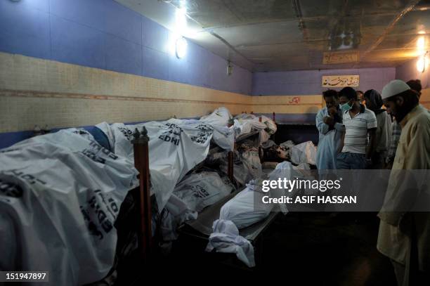 Pakistani men identify their relatives who died in a garment factory fire at the EDHI Morgue in Karachi on September 13, 2012. More than 310...