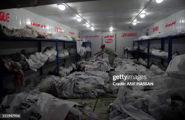 Pakistani EDHI employee identifies a worker's body who died in a garment factory fire at the EDHI Morgue in Karachi on September 13, 2012. More than...