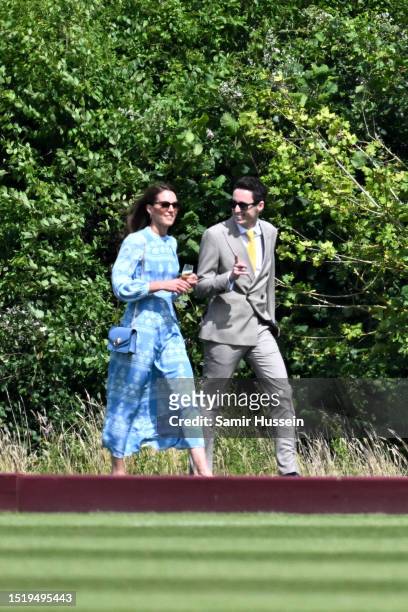 Catherine, Princess of Wales walks with a glass in hand with Lee Thompson ahead of the Out-Sourcing Inc. Royal Charity Polo Cup 2023 at Guards Polo...