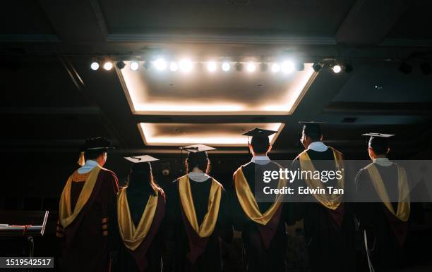 convocation ceremony rear view asian graduation university students together with dean standing on stage for photograph session in a row - dean stock pictures, royalty-free photos & images