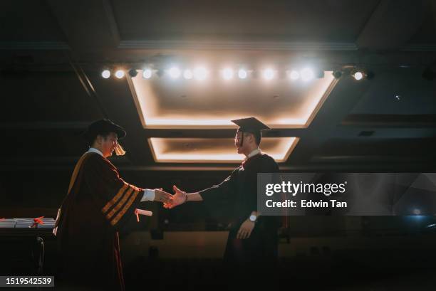 convocation ceremony asian graduation university student handshake with dean on auditorium stage receiving certificate - winner sash stock pictures, royalty-free photos & images