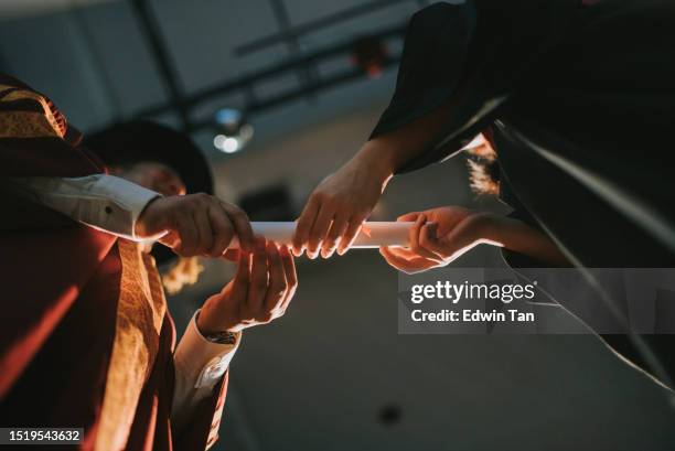 convocation ceremony asian dean hand over graduation university student graduation scroll on auditorium stage - alumni stock pictures, royalty-free photos & images