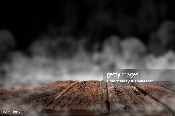 table halloween background of free space for your decoration and dark background of shadows and smoke. desk place for your product or text. wooden table with smoke and black background - black wood material stock pictures, royalty-free photos & images