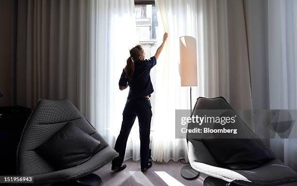 Chambermaid draws the curtains in a bedroom at D&D London Ltd's South Place hotel in London, U.K., on Thursday, Sept. 13, 2012. London hotels'...