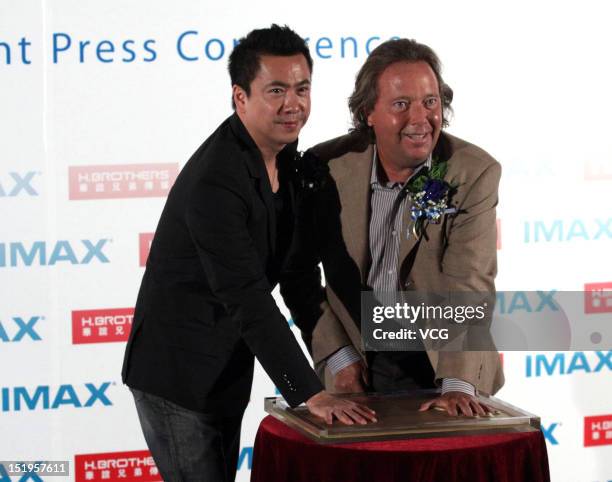 Huayi Brothers Media President Wang Zhonglei and IMAX CEO Richard L. Gelfond make hand imprints during a signing ceremony on September 12, 2012 in...