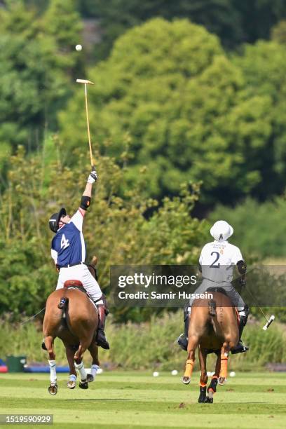 Prince William, Prince of Wales reaches for the ball as he takes part in the Out-Sourcing Inc. Royal Charity Polo Cup 2023 at Guards Polo Club on...