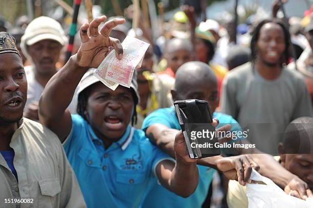 An Anglo platinum mine worker waves money in the air during a strike over disputes about their wages on September 13, 2012 in Rustenburg, South...