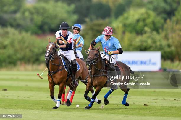 Prince William, Prince of Wales reaches for the ball as he takes part in the Out-Sourcing Inc. Royal Charity Polo Cup 2023 at Guards Polo Club on...