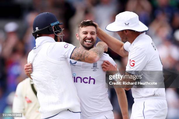 Mark Wood of England celebrates with Ben Stokes and Stuart Broad after dismissing Australia captain Pat Cummins during Day One of the LV= Insurance...