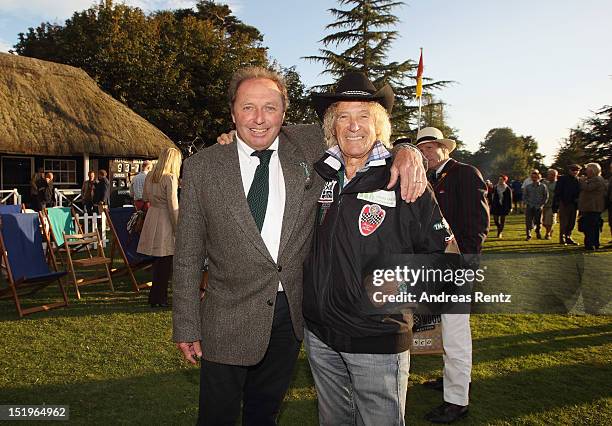 Driver Jochen Mass of Meilenwerk Historic Racing chats with driver Arturo Merzario at the Goodwood Revival 2012 cricket match at the Goodwood House...