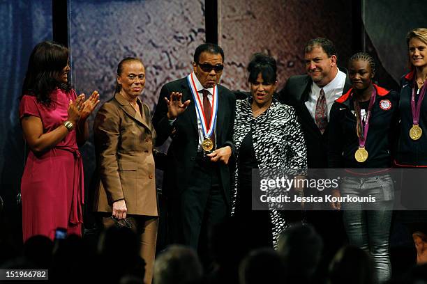 Former boxing champion Muhammad Ali waves to the crowd after being presented with the 2012 Liberty Medal, along side with his daughter Laila Ali ,...