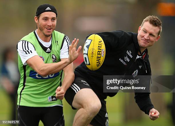 Dale Thomas and Nathan Buckley the coach of the Magpies contest for the ball during a Collingwood Magpies AFL training session at Gosch's Paddock on...