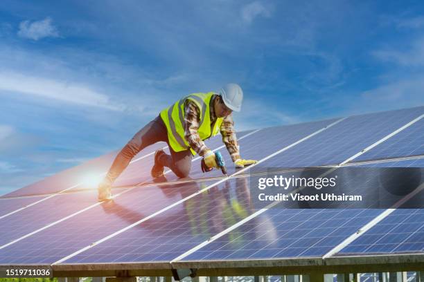 photovoltaic,male engineer installing solar photovoltaic panel system using screwdriver. - lucht en ruimtevaartingenieur stockfoto's en -beelden