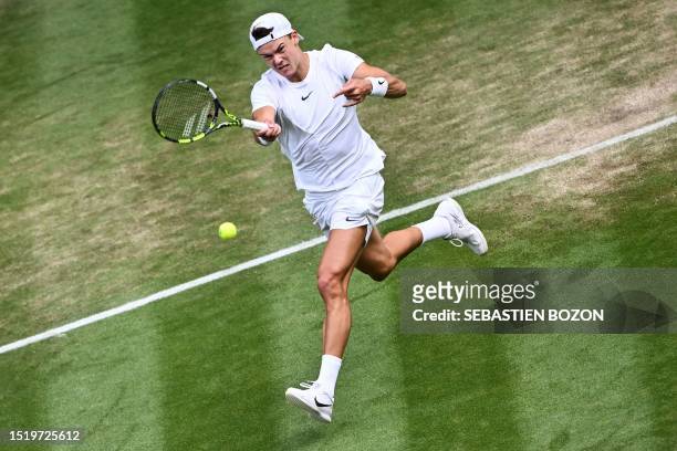 Denmark's Holger Rune returns the ball to Bulgaria's Grigor Dimitrov during their men's singles tennis match on the eighth day of the 2023 Wimbledon...