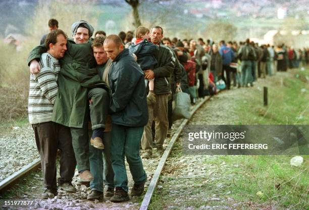 Ethnic Albanian refugees arrive by foot in Macedonia, 01 April 1999 after being forced at the Kosovar village of Djeneral Jankovic, to leave a train...