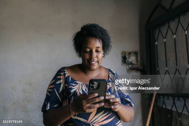 woman using smartphone in humble house - woman starving stock pictures, royalty-free photos & images