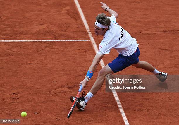 Cedrik-Marcel Stebe of Germany returns the ball to Bernard Tomic of Australia during the Davis Cup World Group Play-Off match between Germany and...