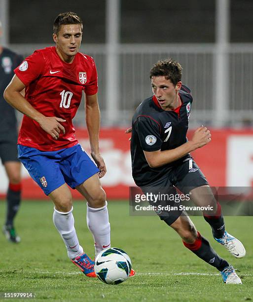 Joe Allen of Wales takes the ball past Dusan Tadic of Serbia during the FIFA 2014 World Cup Qualifier at stadium Karadjordje Park between Serbia and...