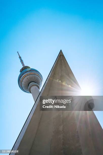 low angle view of berlin communications tower against sunny sky - east berlin stock pictures, royalty-free photos & images