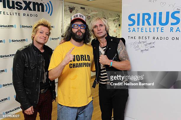 Tre Cool and Mike Dirnt of Green Day pose for a photo with actor Judah Friedlander during their visit to the SiriusXM Studios on September 14, 2012...