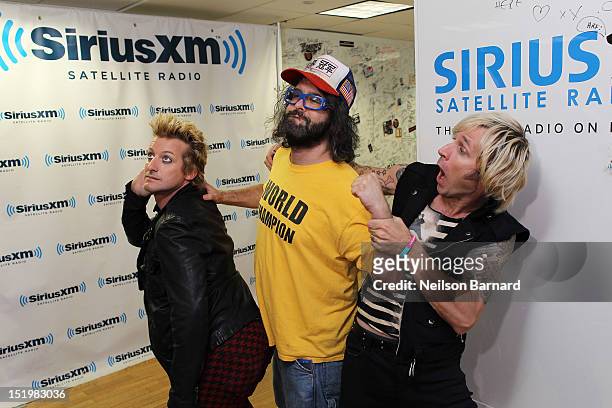 Tre Cool and Mike Dirnt of Green Day pose for a photo with actor Judah Friedlander during their visit to the SiriusXM Studios on September 14, 2012...