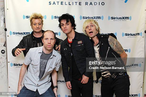Program director Jeff Regan jumps into a photo with Tre Cool, Billie Joe Armstrong and Mike Dirnt of Green Day during the band's visit to the...