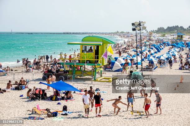 Miami Beach, Florida, crowded beach with sunbathers, lifeguard station.