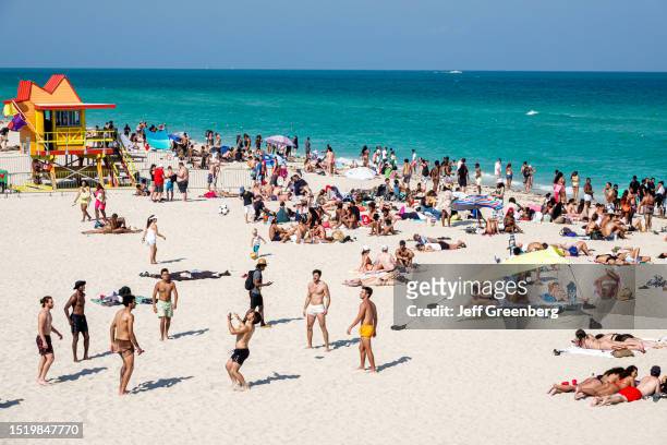 Miami Beach, Florida, crowded beach with sunbathers, lifeguard station.