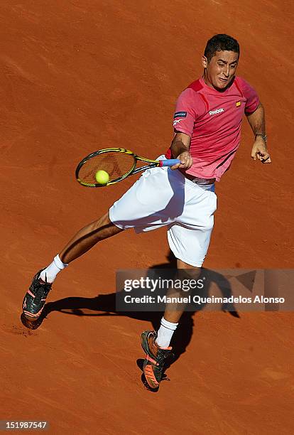 Nicolas Almagro of Spain returns a shot to John Isner of the United States during day one of the semi final Davis Cup between Spain and the United...