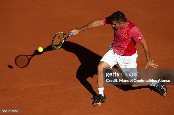Nicolas Almagro of Spain returns a shot to John Isner of the United States during day one of the semi final Davis Cup between Spain and the United...