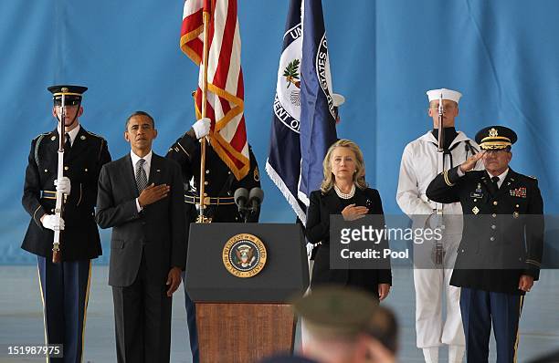 President Barack Obama and U.S. Secretary of State Hillary Clinton hold their hands over their hearts during the Transfer of Remains Ceremony for the...