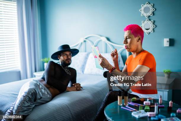 gay couple talking and putting make-up on in the bedroom at home - young crossdresser photos stock pictures, royalty-free photos & images