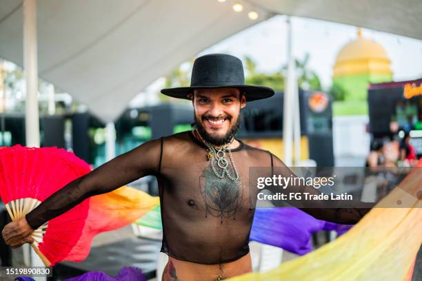 porträt eines jungen mannes mit pride-flagge auf einem schwulen festival - annual latin pride festival stock-fotos und bilder