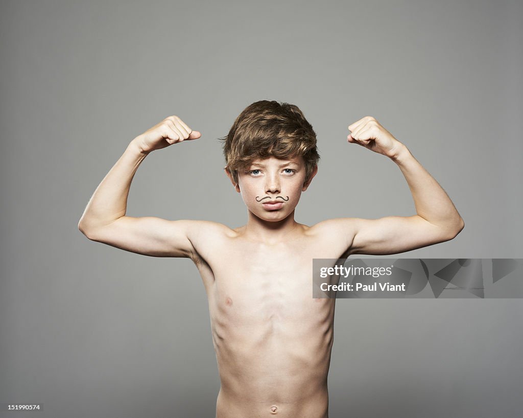 Teenage boy showing muscles