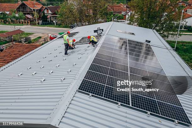 male workers installing solar panels - nature resources and conservation agency stock pictures, royalty-free photos & images